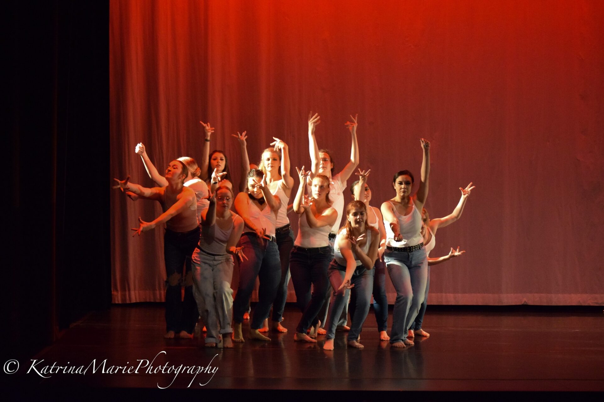 Group of dancers dressed in white tanks and blue jeans dancing to Queen's "Body Language"